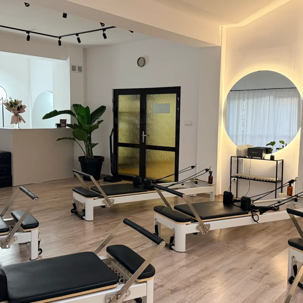 Jasne wnętrze LIMA Pilates Studio z lustrami i reformerami do pilatesu
